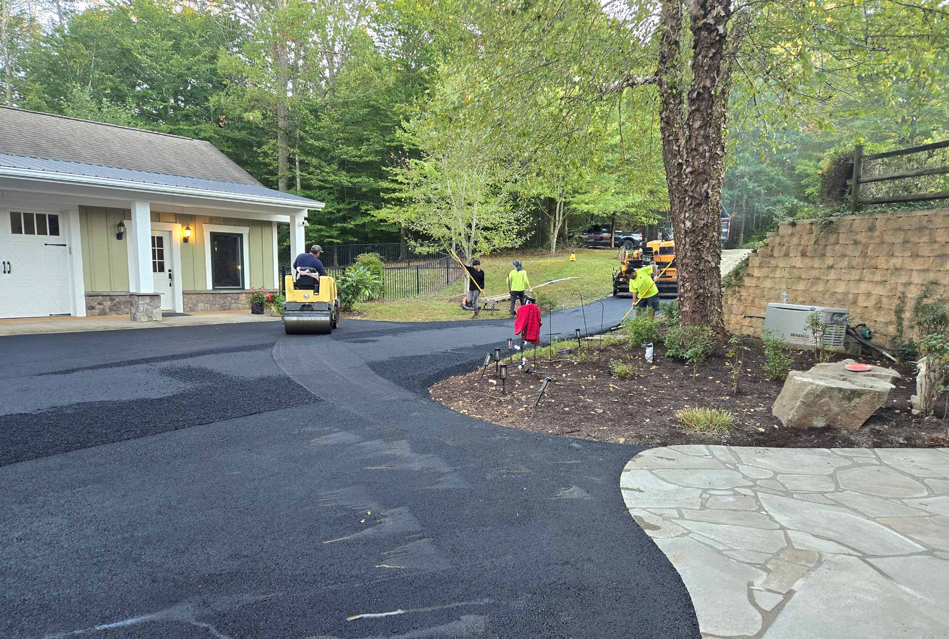 Workers from HOTMIXX LLC paving a driveway