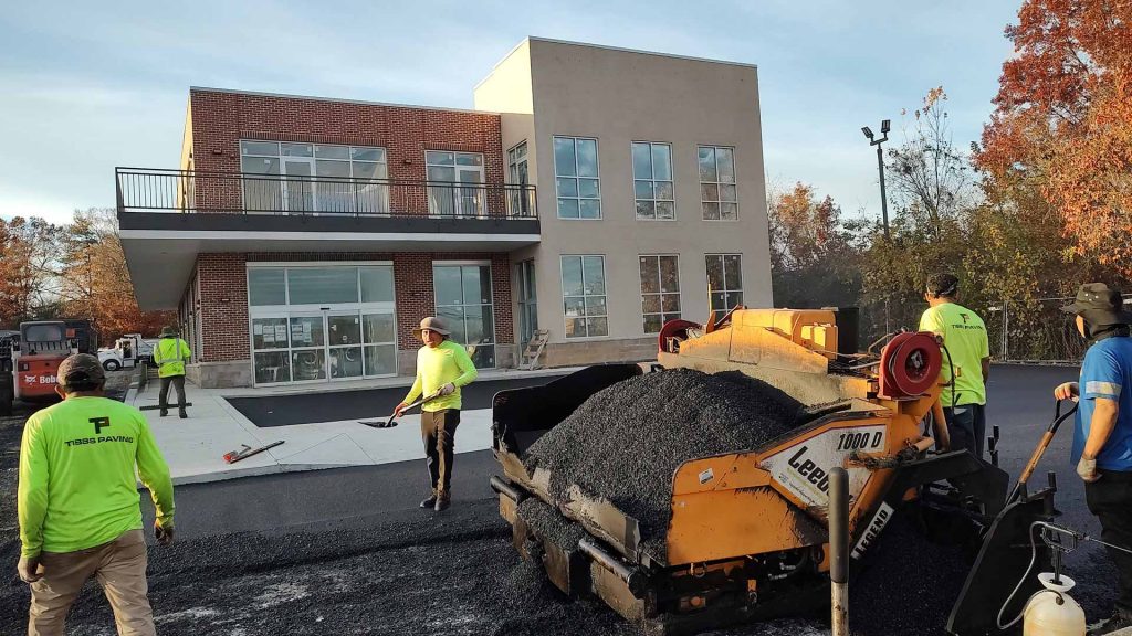 Workers from HOTMIXX LLC paving a parking lot